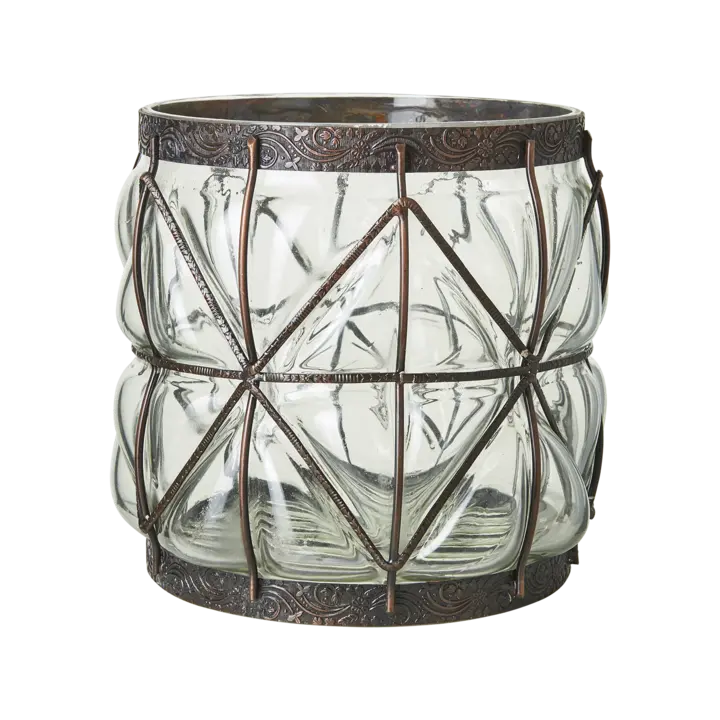 Skulpturell glassvase i klart glass med brun metalldetalj, dekorativ og håndlaget stil, plassert i varmt og stemningsfullt interiør.