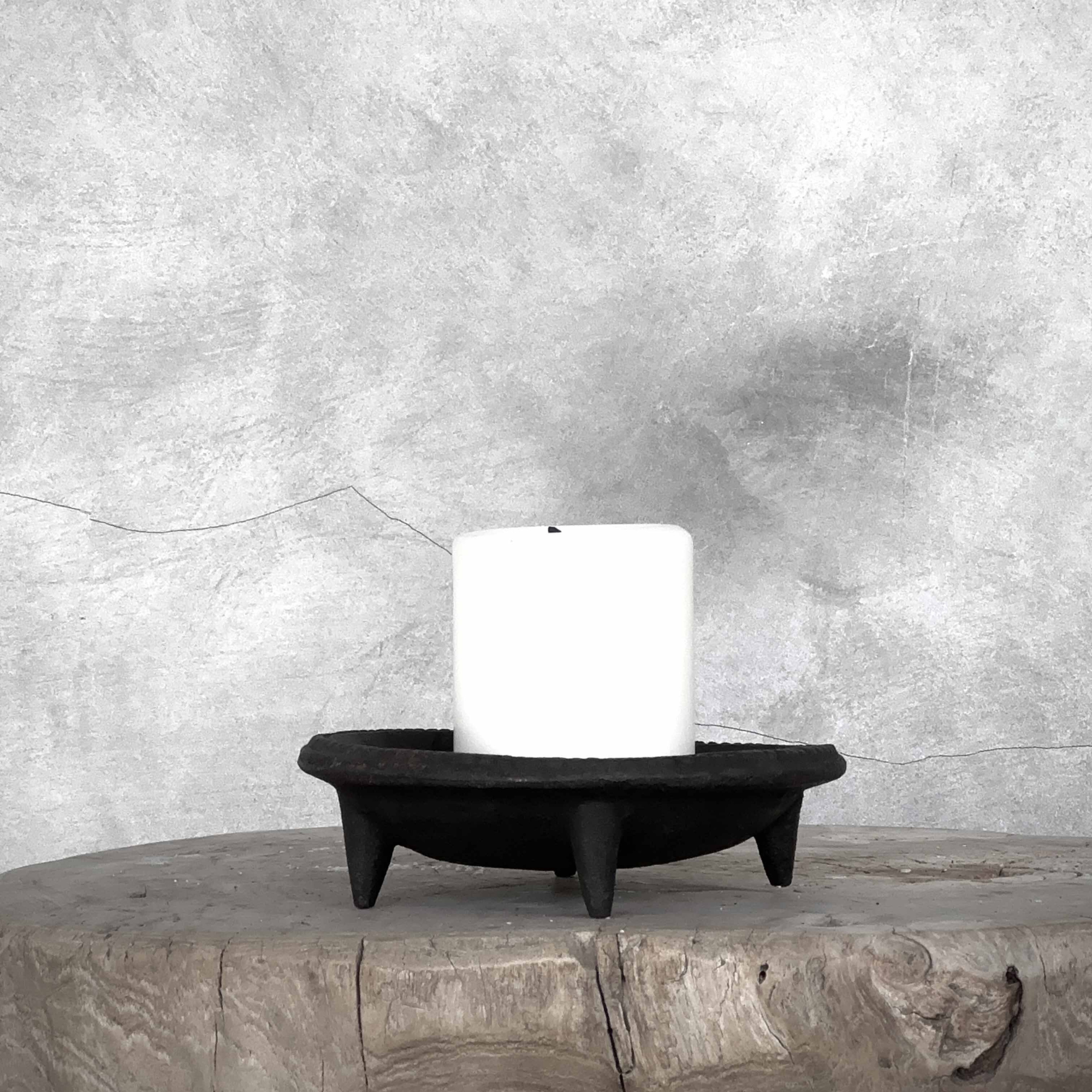 Lysestake i sort støpejern på trebord.