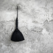 en svart cipillo kost i vaintage stil hengende på murvegg