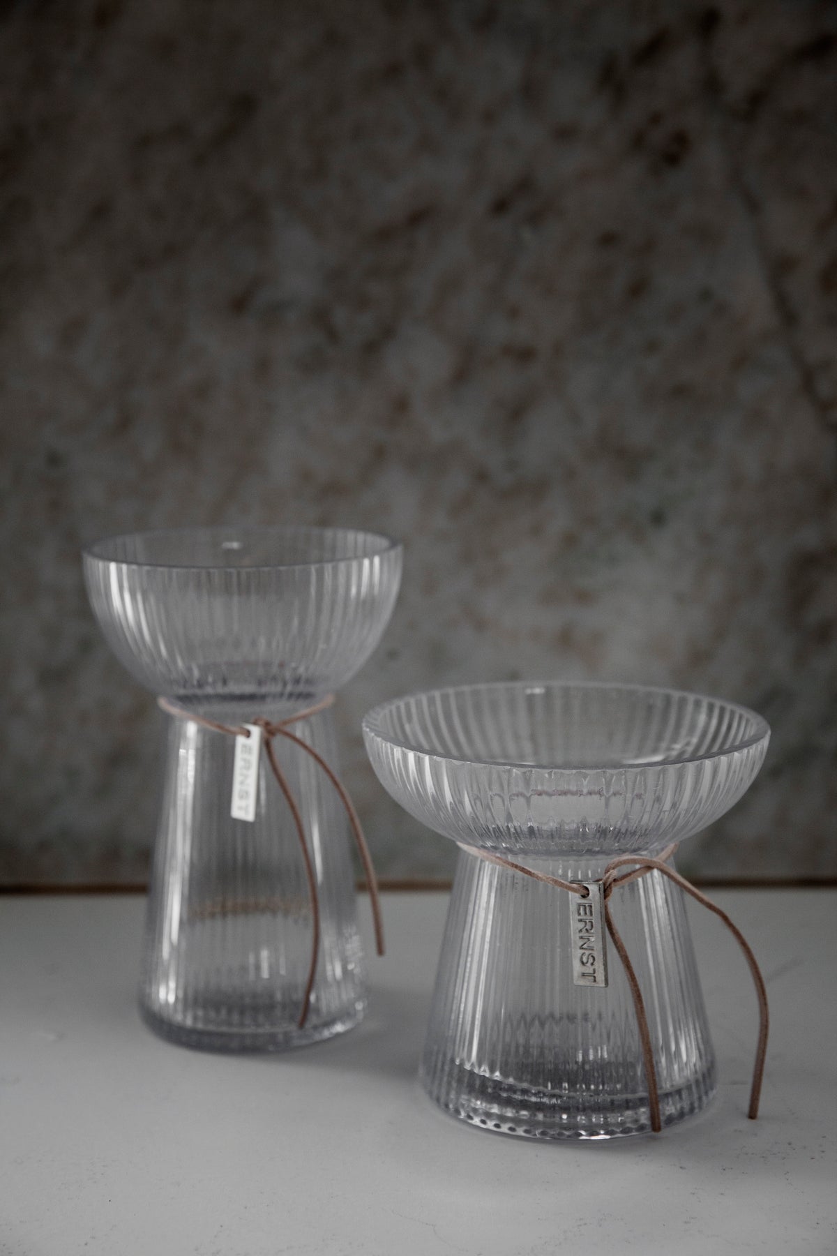 Liten riflet glassvase med blomster i interiør