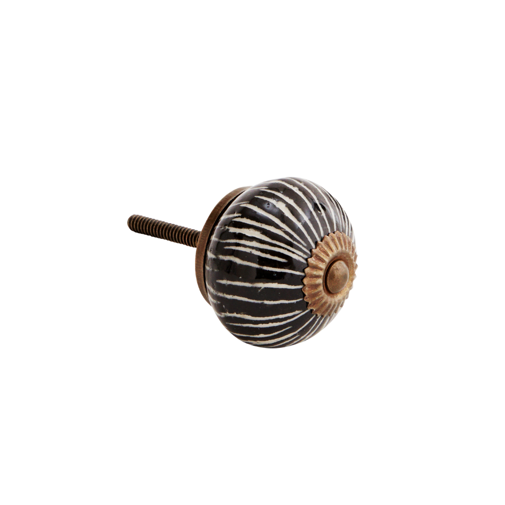 Håndmalt dørknott i steingods med hvite striper på sort bunn og messingdetaljer fra Madam Stoltz.