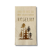 Serviett med tekst «Her er det så inni granskauen koselig» i bambus med skogmotiv i varme naturfarger