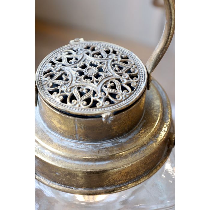 Detaljbilde av lanterne glass og gull lokk