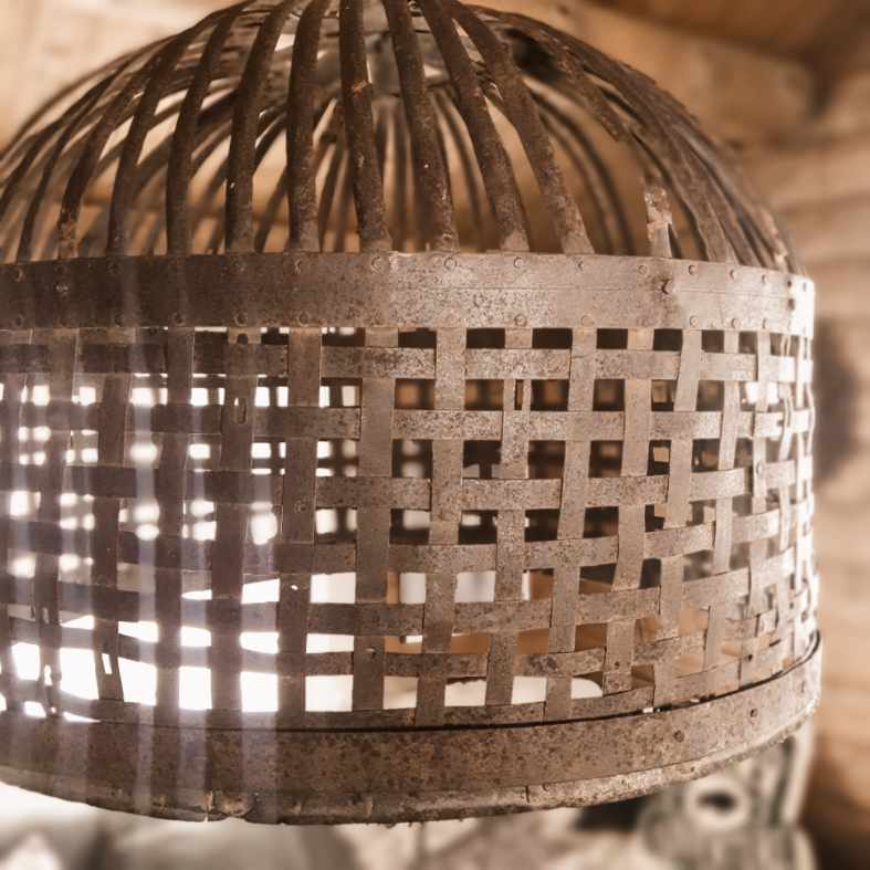 Rustikk lampeskjerm i jern med flettet mønster og vintage overflate – nærbilde