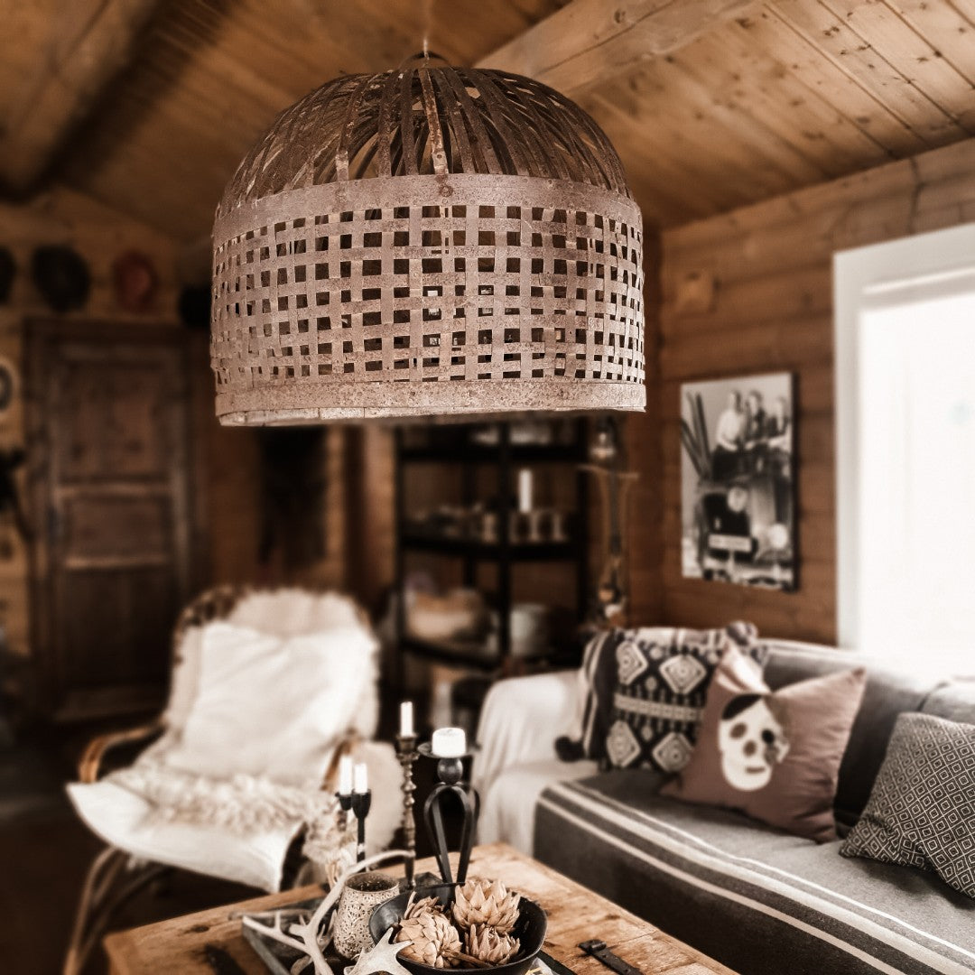 Stor rustfarget jernlampe som pendel i stue med industriell og rustikk innredning