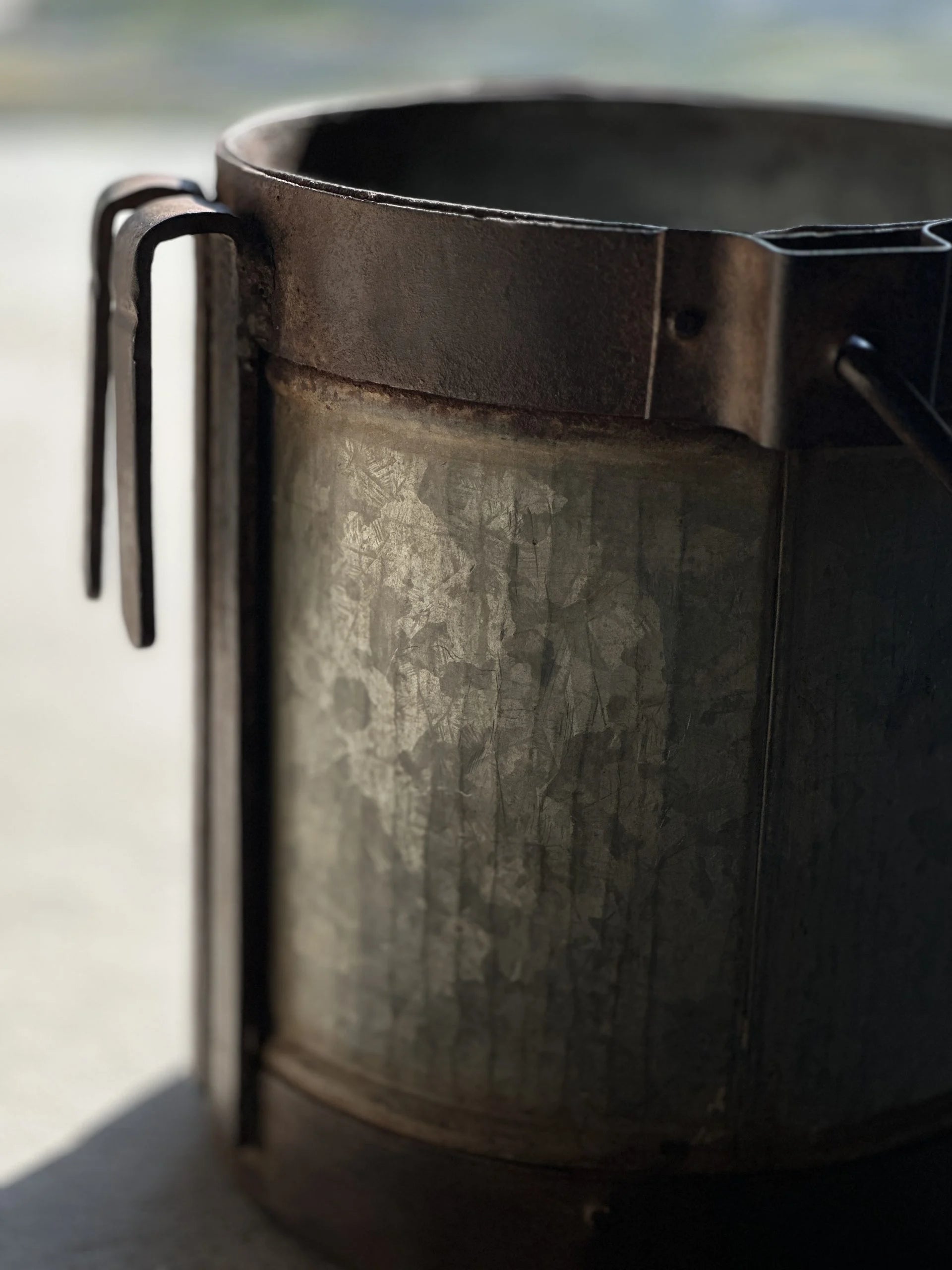 Nærbilde av vintage melkespann i metall med rustikk patina