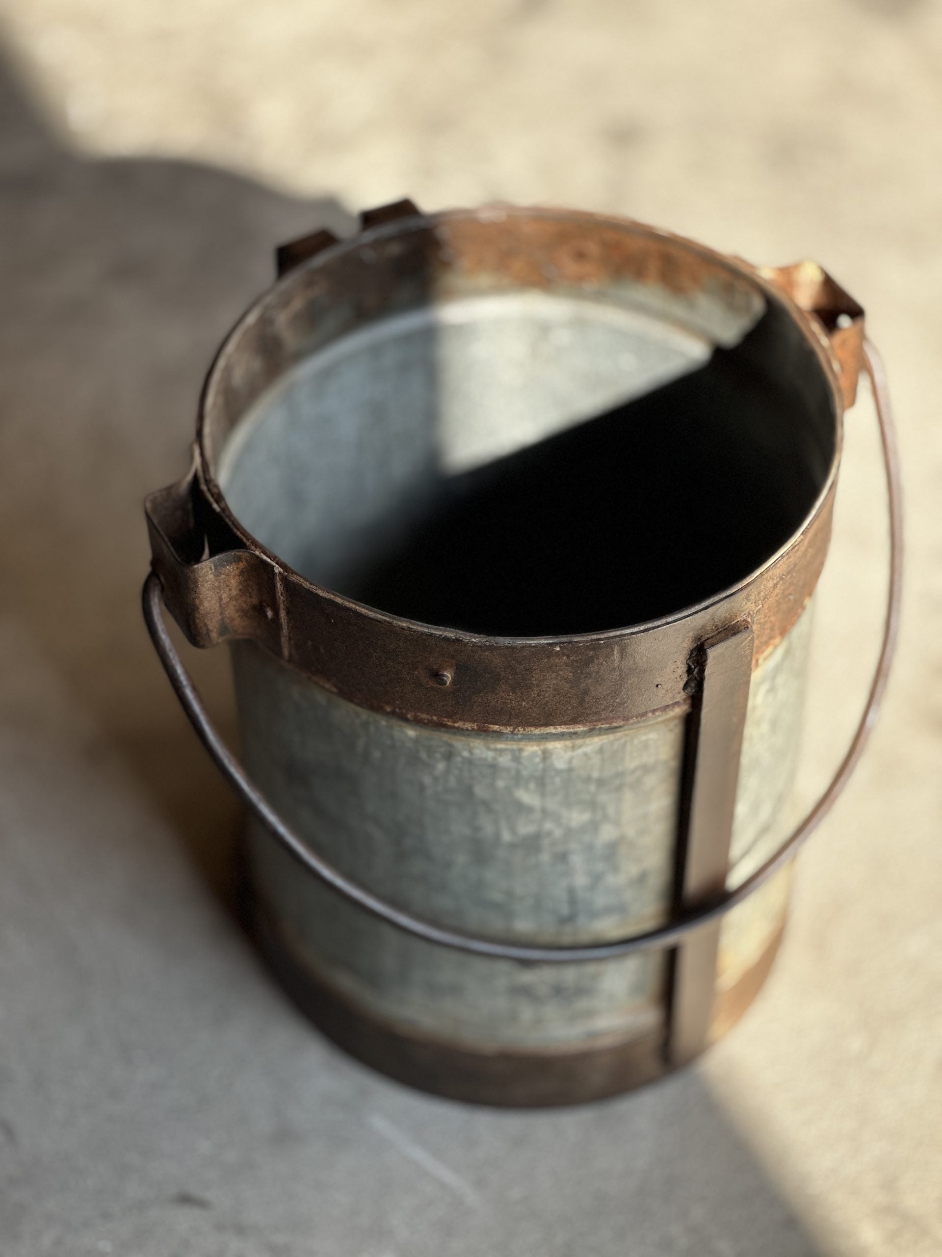 Rustikk melkepotte i metall med håndtak – toppvinkel